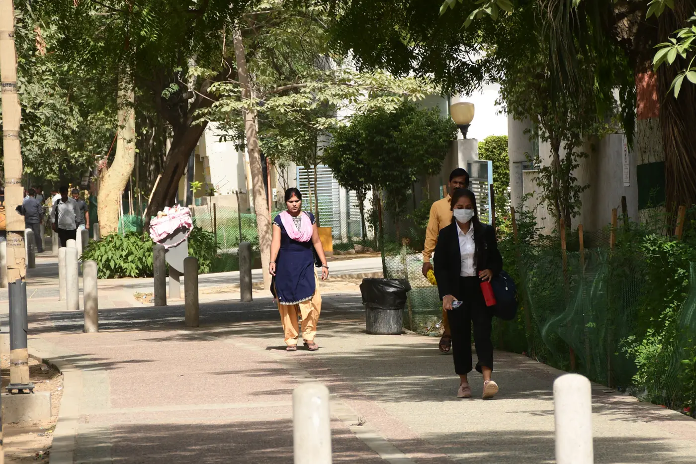 A woman walking safely along a newly built, tree-shaded footpath