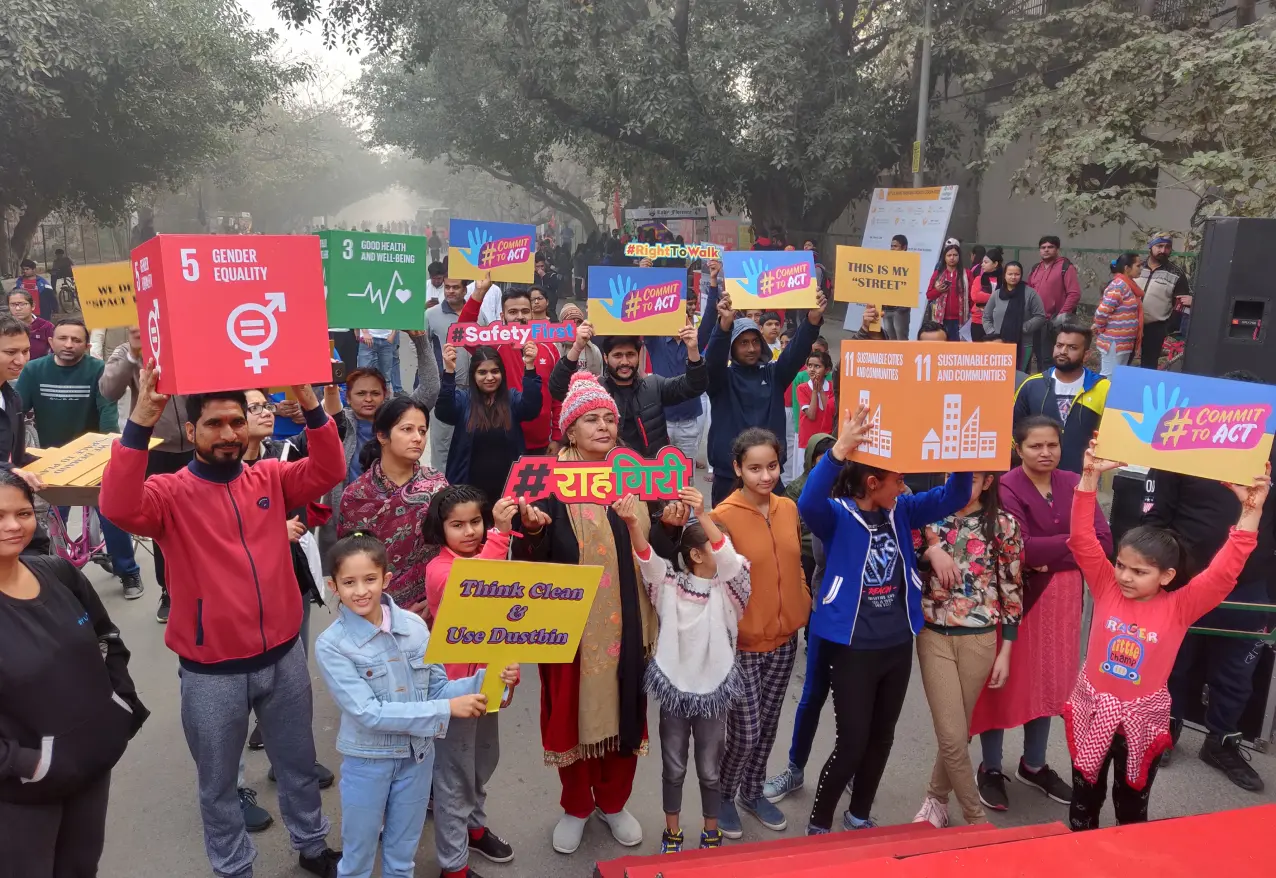 Children holding Sustainable Development Goal placards on a street closed to traffic