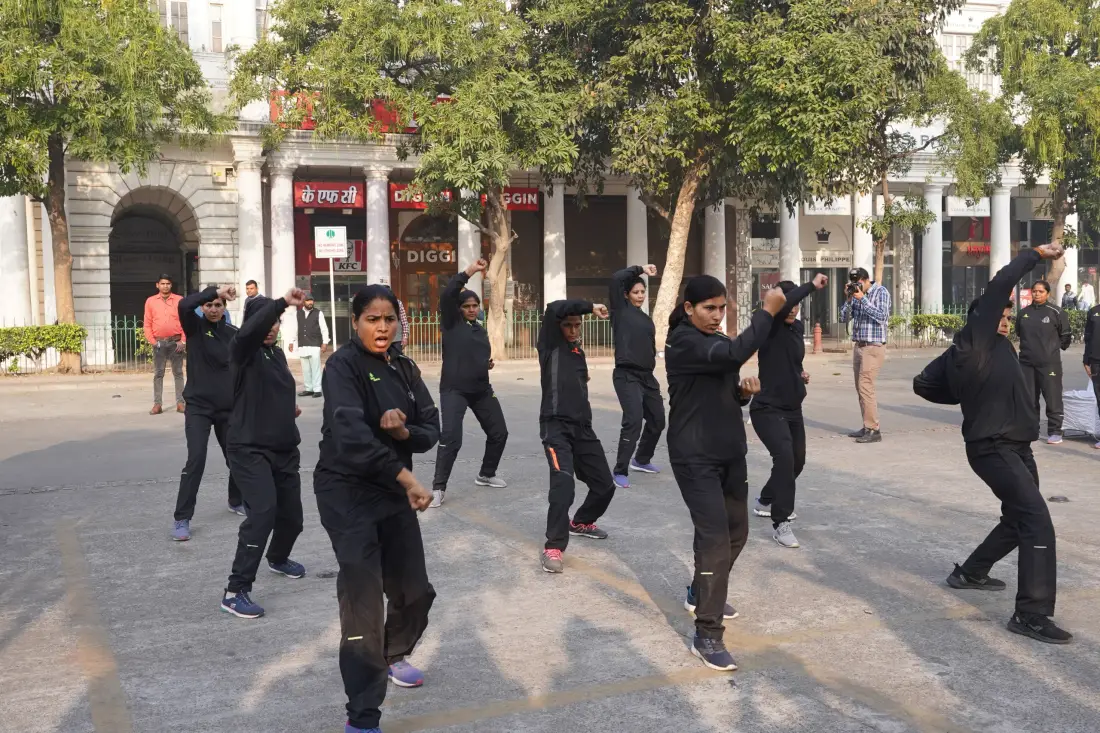 Women dancing on a street beside a heritage building