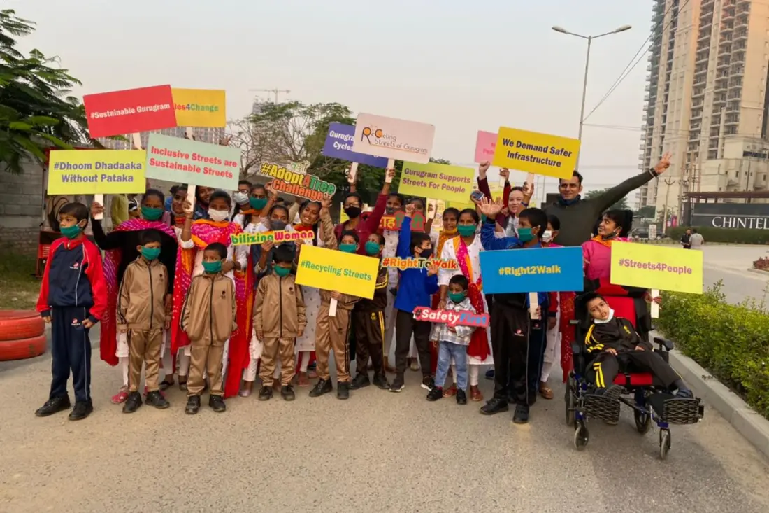 Women and a wheelchair user holding placards for inclusive streets