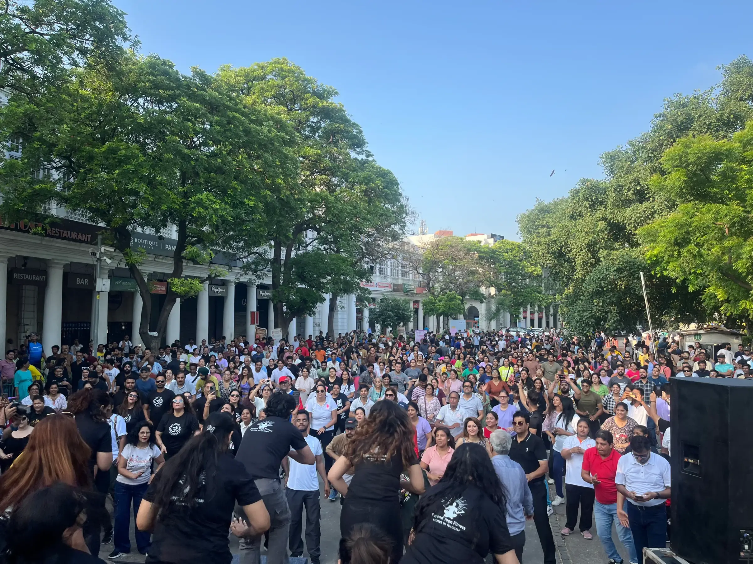 Thousands of residents walking down a tree-lined avenue closed to cars during a Raahgiri Day