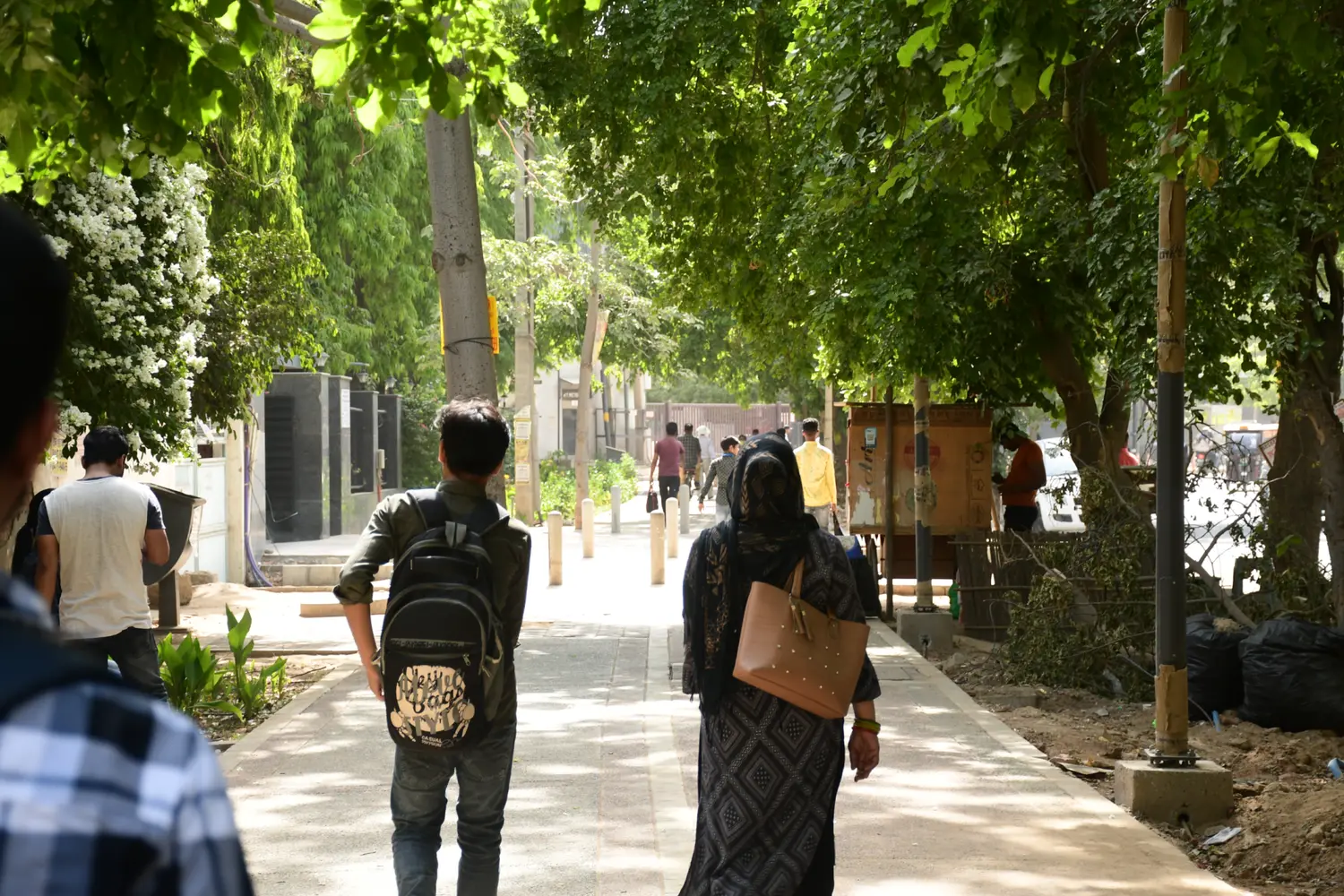 Pedestrians walking along a rebuilt footpath separated from traffic