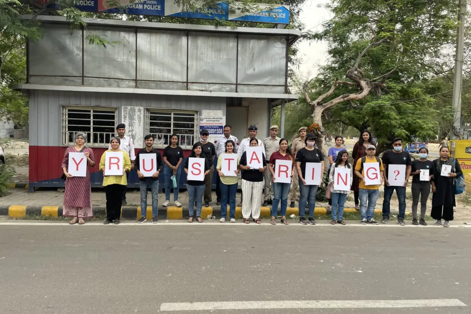 Residents standing in a line holding letters that spell a road safety message